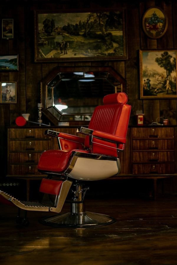 The red chair standing under the wall of framed pictures in the back room