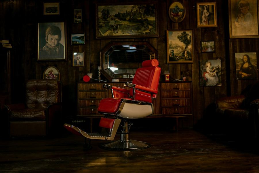The red chair below the wall of framed pictures